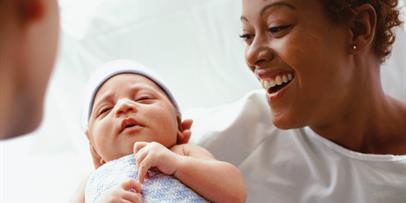 Black mother receiving her infant after birth