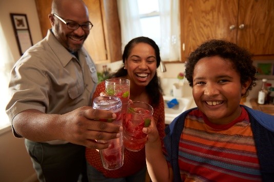 Bi-racial family in their kitchen celebrating healthy refreshments