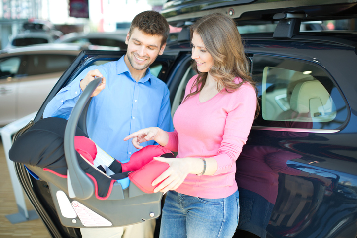 Couple looking at baby in a carseat