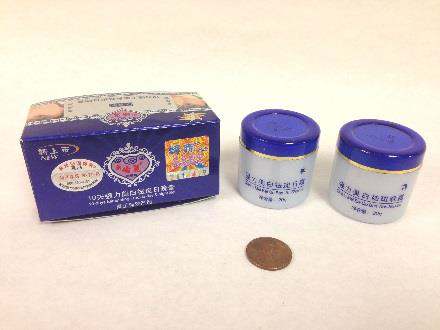two round face creams with clear bottoms and blue caps next to their blue box with chinese lettering