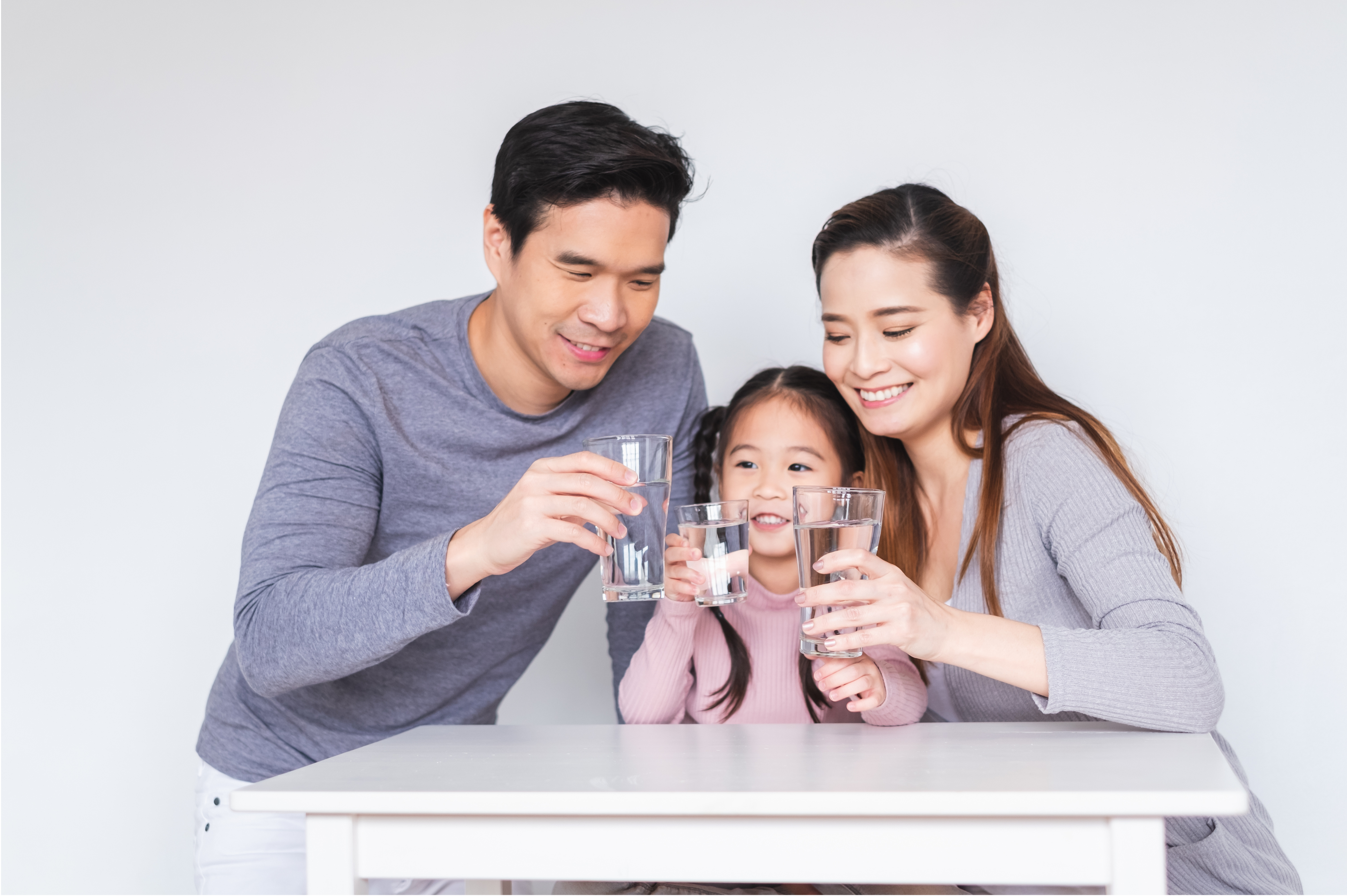Family drinking water from glasses