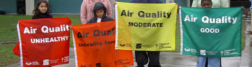 children holdin up air quality signs