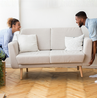 Two people moving a couch