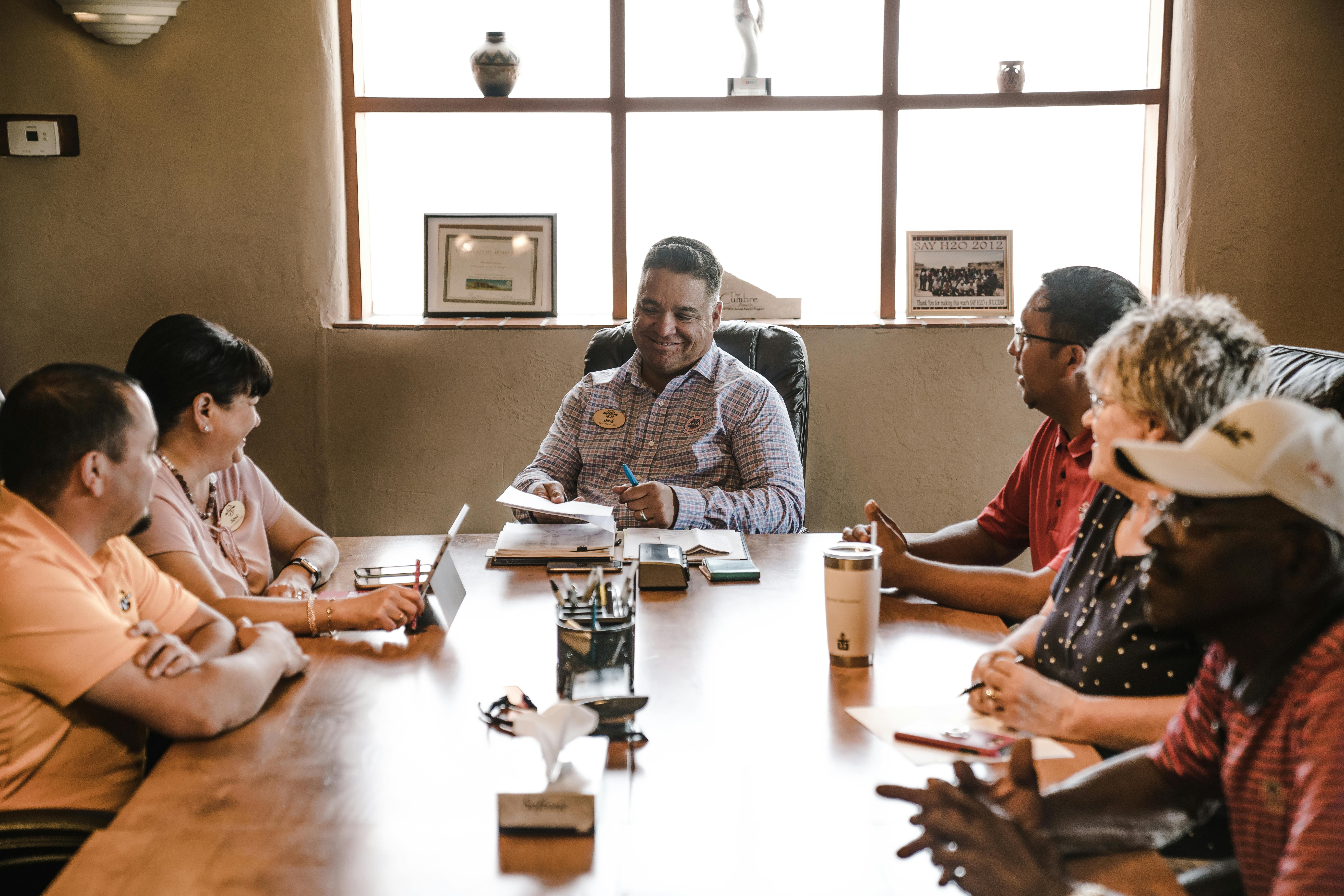 People around a table at a community meeting People around a table at a community meeting