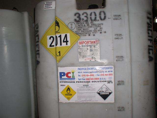Labels on a white plastic tub say Hydrogen Peroxide Solution 50 percent, with warnings that say Corrosive, Oxidizer, and other small print warnings that say Important.