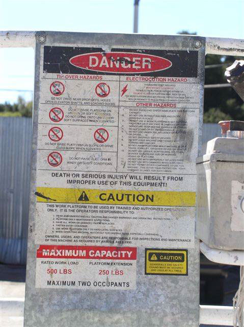 A warning placard posted to the railings of the lift describe various warnings in small print for the operator.