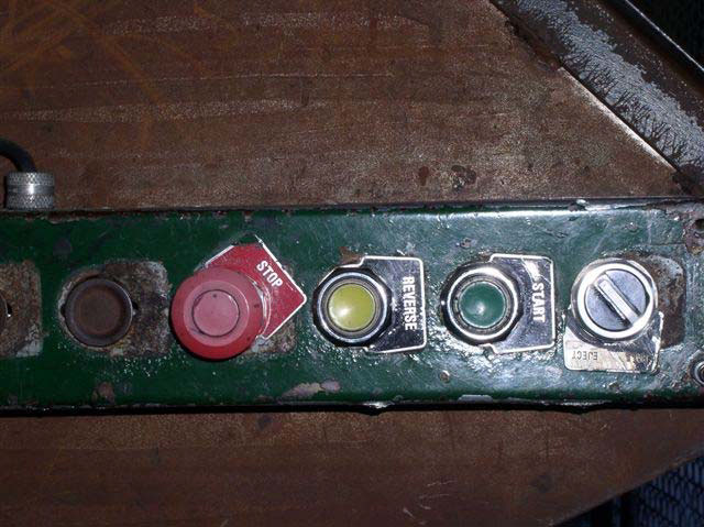 The control panel for the machine shows three buttons and a knob in a horizontal arrangement. A red button on the left says Stop; a yellow is Reverse; Green is Start; and the knob is labeled Eject.