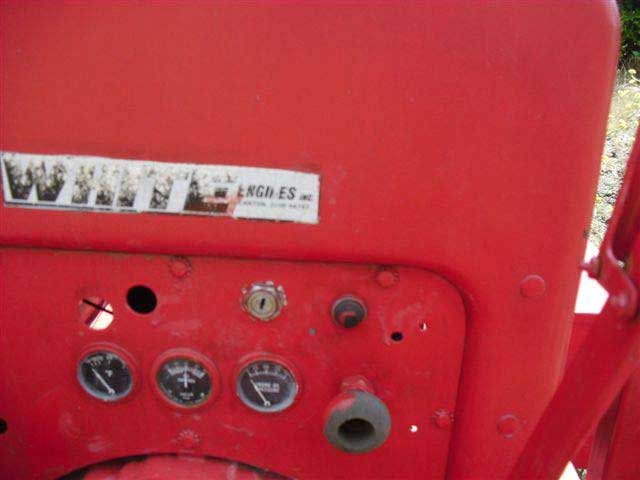 The control panel on the wood chipper has an ignition key slot, a button, and below that three analog gauges. The panel has been repainted.