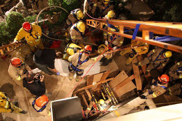 The scene of the worker recovery, showing more than 15 rescue personnel working to recover the buried worker.