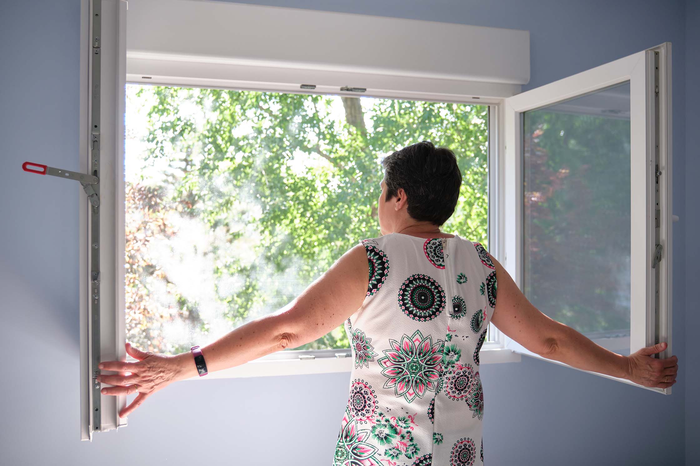 woman standing by open window