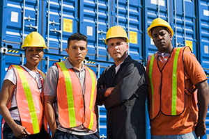 Dock workers standing in front of containers outside