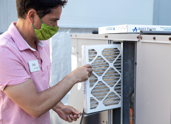Image of man fixing an heating ventilationa and air conditioning system.