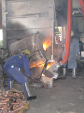 Workers pour molten metal at a foundry