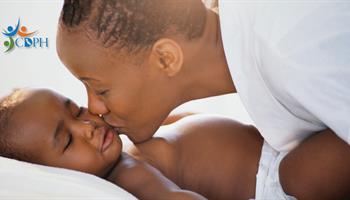 Black mother kissing sleeping infant lovingly