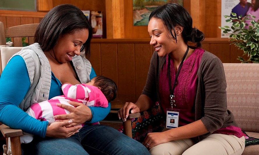 Health professional attending to a breastfeeding mother