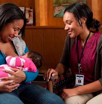 Health professional attending to a breastfeeding mother