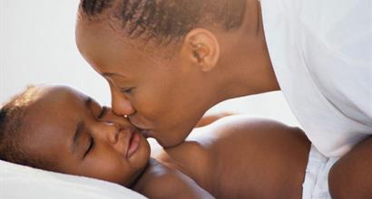 Black mother embracing sleeping infant