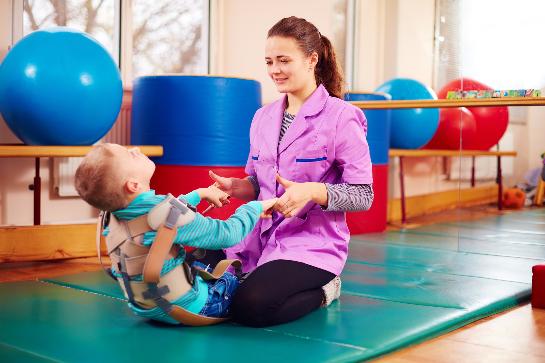 Physical therapist assisting child with special health care needs