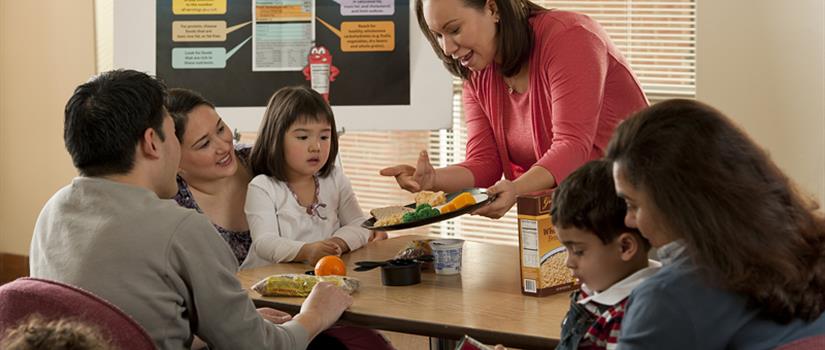 Nutritionalist presenting a well-portioned plate to a small group in a classroom setting