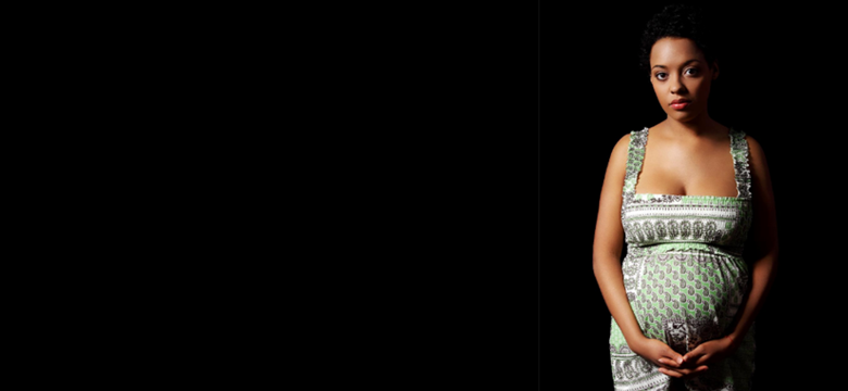 single pregnant women against black background