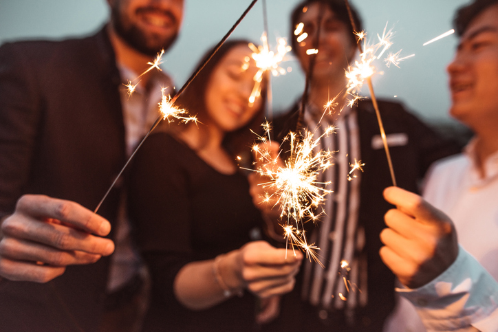 Group of friends celebrating the New Year with sparklers