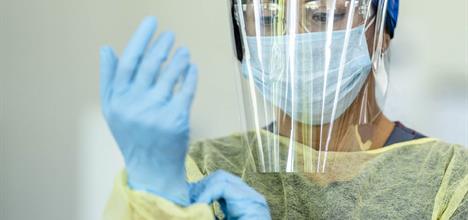 A photo of a female health professional wearing PPE.