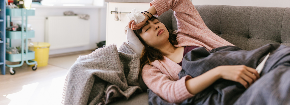 Woman laying on couch feeling sick