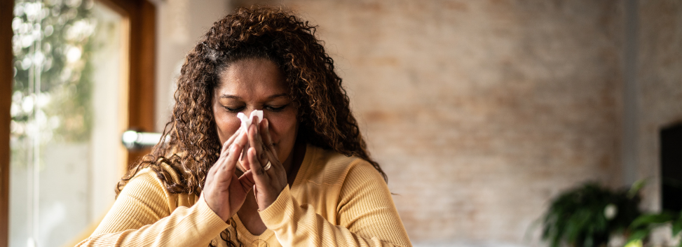 Woman with cold blowing her nose
