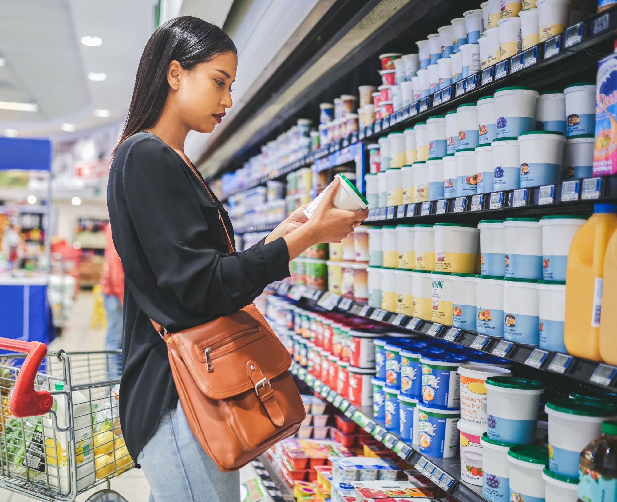 Woman reading the label on a dairy product at the grocery store