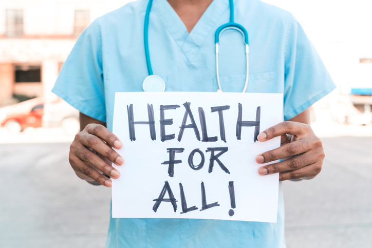 Medical Professional holding "Health for all" sign Medical Professional holding "Health for all" sign