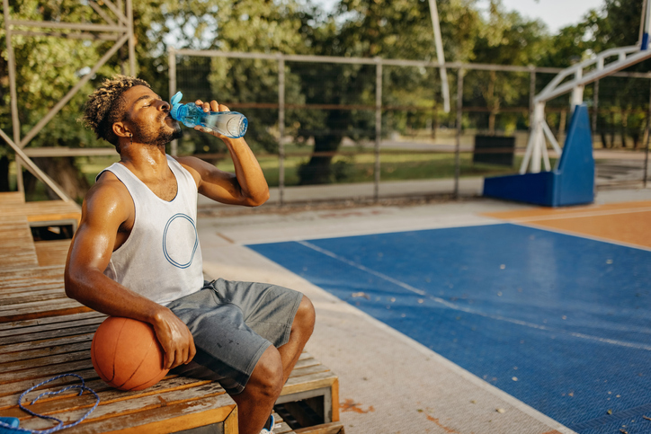 Basketball player resting and drinking water