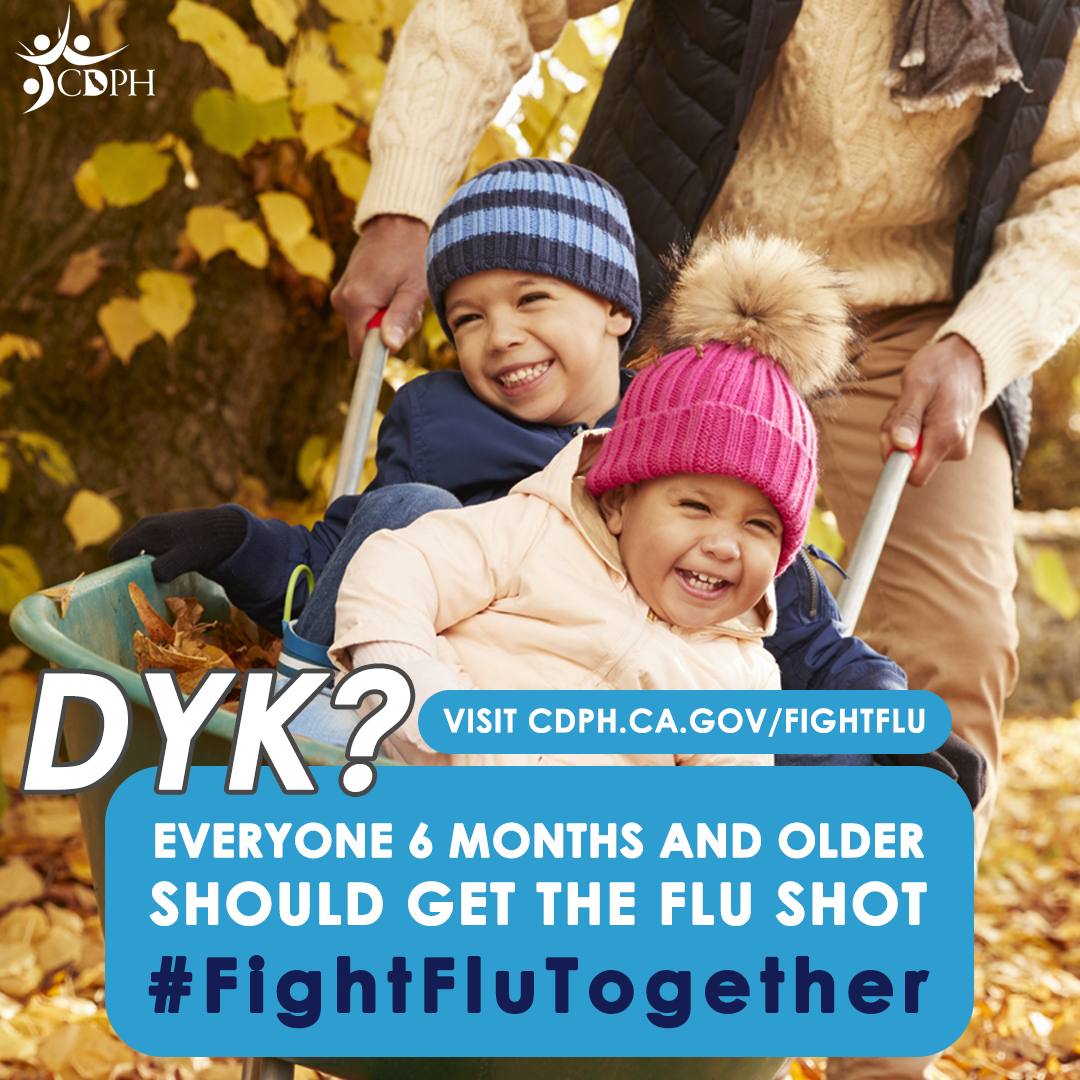Dad pushing wheelbarrow with boy and girl smiling with text overlay, "DYK? Everyone 6 months and older should get the flu...