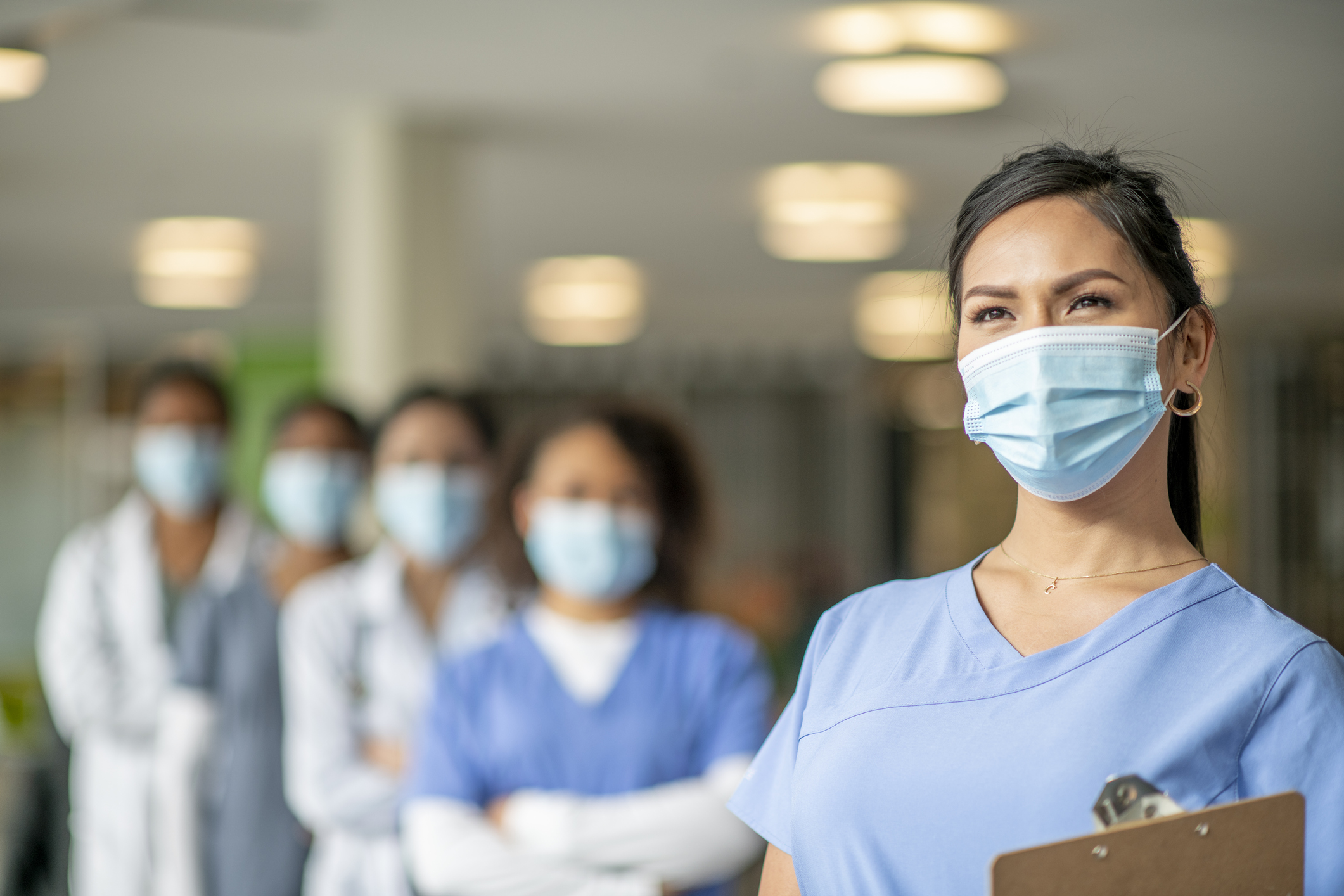 A nurse with other nurses in the background. A nurse with other nurses in the background.