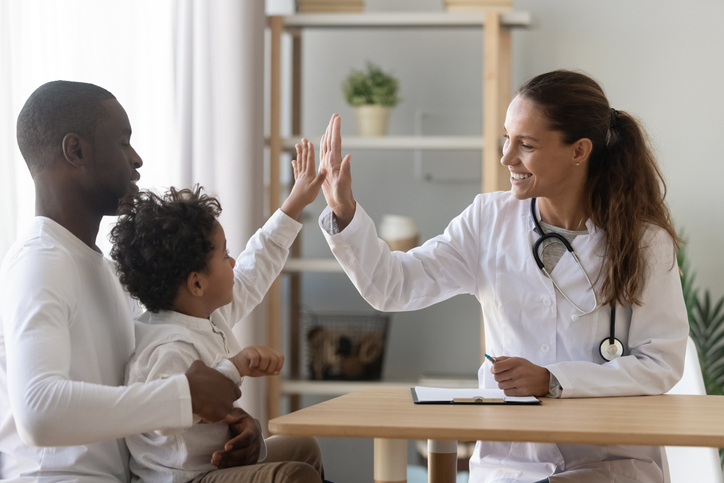 Physician giving child high-five Physician giving child high-five